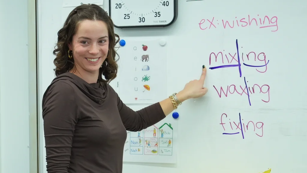 Teaching showing suffixes examples on whiteboard.