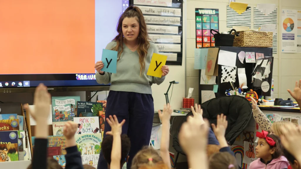 Teacher doing whole class lesson on suffixes with flash cards.