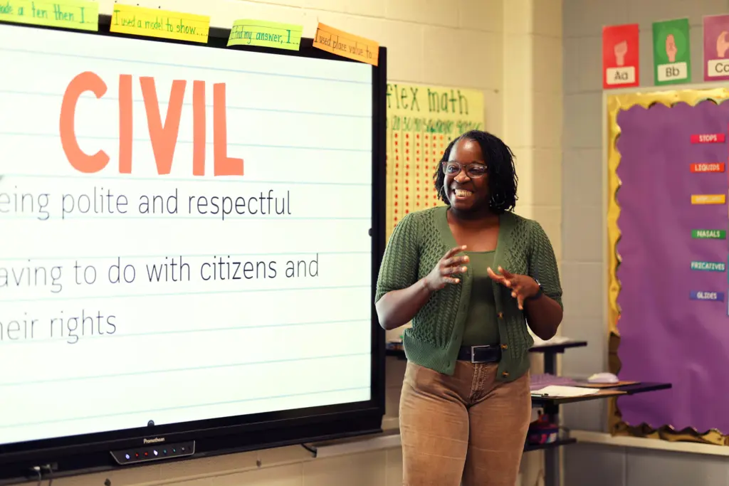 Teacher in front of smart board with the word Civil and its definitions.
