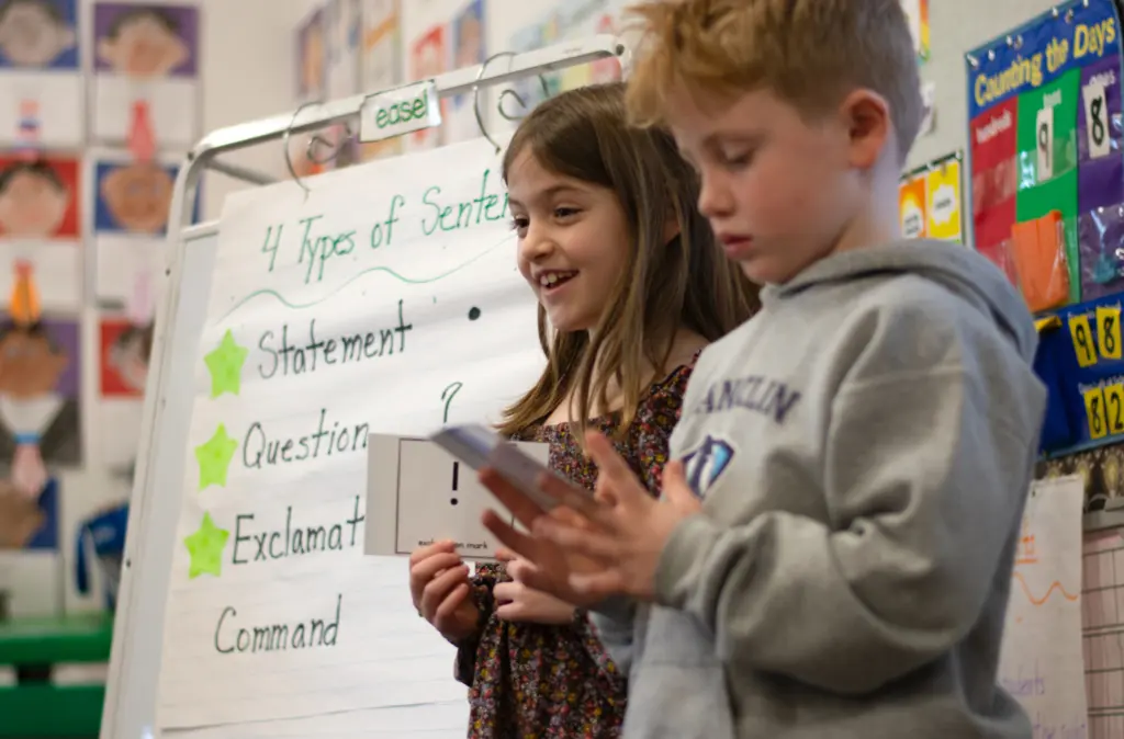 Students using flash cards in front of classroom.