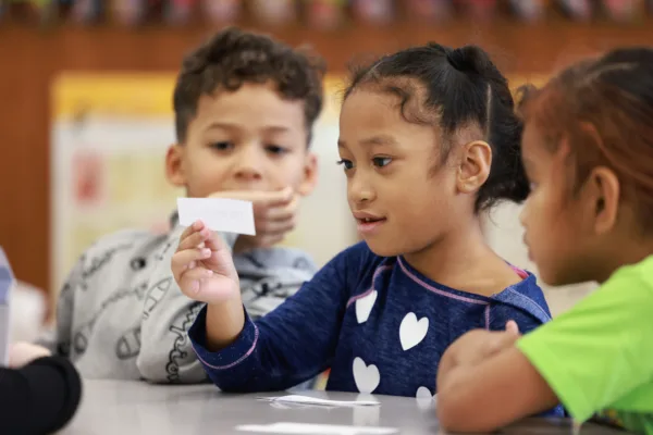 Student looking at slip of paper in small group.